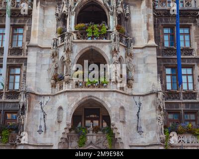 Fassade des neogotischen Rathauses mit täglichen Aufführungen zum Glockengeräusch und einem hohen Turm mit Blick auf die Stadt am Marienplatz München Stockfoto