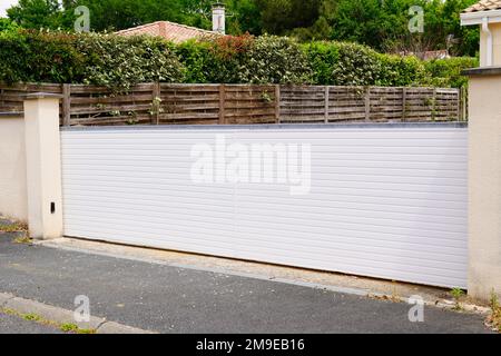 Portal-Aluminium-Schiebetor aus weißem Metall am Eingang des modernen Vorstadthauses Stockfoto