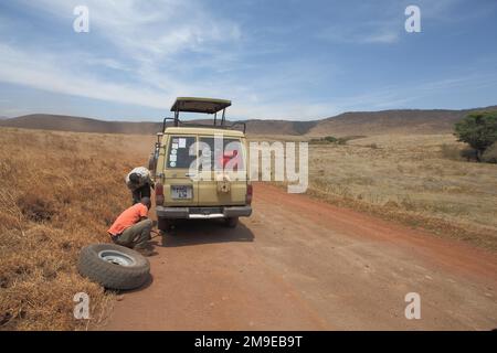 Jeep mit Reserverad Reifenwechsel aufgrund einer Panne im Ngorongoro-Krater, Serengeti, Tansania Stockfoto