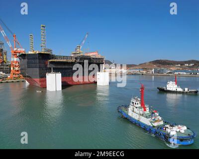 YANTAI, CHINA - 18. JANUAR 2023 - Ein Schlepper transportiert eine Schiffsanlagenkomponente auf der Baustelle CIMC Raffles in Yantai, Ostchina Shandong PR Stockfoto