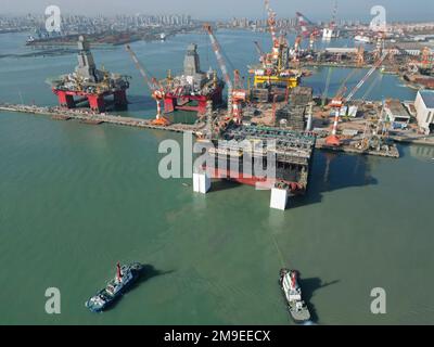 YANTAI, CHINA - 18. JANUAR 2023 - Ein Schlepper transportiert eine Schiffsanlagenkomponente auf der Baustelle CIMC Raffles in Yantai, Ostchina Shandong PR Stockfoto