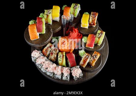 Sushi-Brötchen im Sortiment auf schwarzem Hintergrund Stockfoto