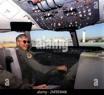 KC-10 Flugdeck, mittlere Aufnahme, Rückansicht rechts, Brigadegeneral Steven A. Roser, USAF, Commander 60. Air Mobility Wing, Luftwaffenstützpunkt Travis, Kalifornien, auf dem Pilotensitz für seinen letzten Flug auf einem KC-10A Extender. Teil seiner „fini“-Flugfestlichkeiten, die zu seinem Rücktritt von der United States Air Force nach 29 Jahren engagierten Dienstes führten, 60. Air Mobility Wing Change of Command Zeremonie. Die Travis-Fluglinie ist am Horizont im Hintergrund. Basis: Luftwaffenstützpunkt Travis Bundesstaat: Kalifornien (CA) Land: Vereinigte Staaten von Amerika (USA) Stockfoto