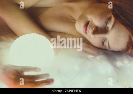 Nahaufnahme einer ruhigen Frau, die ein Porträtbild der Lichtkugel hält Stockfoto