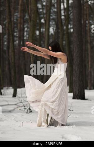 Geheimnisvolle Frau mit flatterndem weißen Kleidertuch auf windszenischer Fotografie Stockfoto