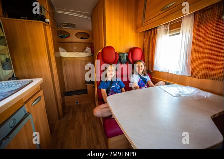 Kinder auf den Rücksitzen im Wohnmobil. Das Innere des Wohnmobils während des Familienurlaubs. Kindersicherheit auf Reisen. Stockfoto