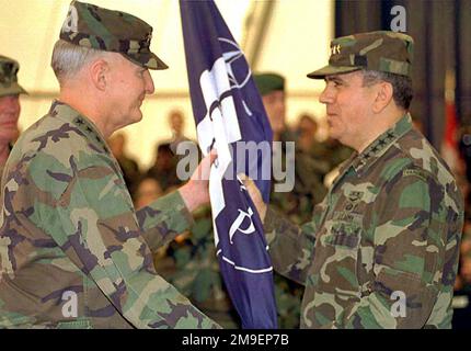 GENERAL George A. Joulwan (USA), Supreme Allied Commander Europe (SACEUR), übergibt den NATO/IFOR-Standard (Flag) an GEN William W. Crouch (USA), Commander Allied Land Forces Central Europe, Während der Zeremonie zur Übertragung der IFOR-Befehlsgewalt von den alliierten Streitkräften Südeuropas an die Alliierten Landstreitkräfte Mitteleuropas, die am Internationalen Flughafen in Sarajewo, Bosnien-Herzegowina, während der Operation Joint Endeavor stattfand. Die Operation Joint Endeavor ist eine Friedensbemühung einer multinationalen Implementierungstruppe (IFOR), die sich aus NATO- und nicht-NATO-Streitkräften zusammensetzt und zur Unterstützung der Dayt nach Bosnien entsandt wird Stockfoto