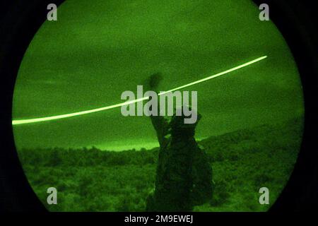 Linkes Profil mittlere Aufnahme in der Nacht durch ein Starlight-System wie Überleben, Flucht, Widerstand und Flucht der US Air Force (S.E.R.E.) Ausbilder SENIOR AIRMAN Chris R. Flamm vom 22. Trainingsgeschwader, Luftwaffenstützpunkt Fairchild, Washington, versucht, Kontakt zu Such- und Rettungskräften (SAR) aufzunehmen, Truppen mit seiner „Buzzsaw“, einem Infrarot-Nachtstift, der am Fallschirmseil befestigt ist. Desert Rescue ist die Premiere der Such- und Rettungsaktion (SAR), die an den Bergen der Fallon Naval Air Station, Nevada, durchgeführt wird. Diese Mission ist eine indirekte Unterstützung von Übung Desert Rescue VIII Einsatzgebiet/Serie: WÜSTENRETTUNG Stockfoto