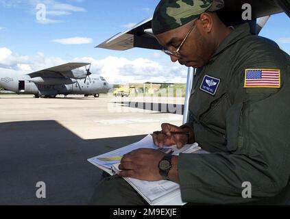 Profil links, mittlere Nahaufnahme, wie der USAF Technical Sergeant Fred Hall, ein C-130-Ladermeister der 37. Airlift Squadron, 86. Airlift Wing, Luftwaffenstützpunkt Ramstein, Deutschland, das Gewicht und Gleichgewicht des Flugzeugs überprüft, bevor er den Hoedspruit Air Force Base, Südafrika verlässt, um US-Personal zu liefern (Fracht und Personal nicht abgebildet) Und Lieferungen an Beira, Mosambik, während der Operation Atlas Response. Die US-Flugzeuge werden nach Südafrika entsandt, um humanitäre Hilfe für die Menschen (nicht abgebildet) zu leisten, die in den überfluteten Regionen Mosambiks aus ihren Häusern gedrängt wurden. Ein rechtes Seitenprofil eines USAF C-130 H Stockfoto