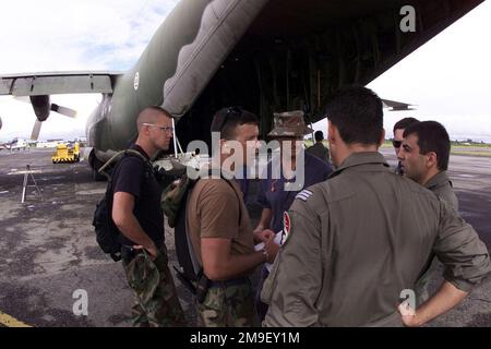 Mittlere Aufnahme. Captain Jeff Burrell, Verantwortlicher für Logistikpläne und Fracht, vom Hauptquartier, US Air Forces Europe, Luftwaffenstützpunkt Ramstein, Deutschland, spricht mit Captain Luis Teixira, einem portugiesischen C-130-Piloten, der der 501. Staffel zugeteilt wurde, aus dem Luftwaffenstützpunkt Montijo, Portugal, Über die Beladung seines Flugzeugs am Internationalen Flughafen in Maputo, Mosambik, Afrika, 17. März 2000. Die Teams werden nach Maputo entsandt, um die Operation Atlas Response zu unterstützen, eine humanitäre Hilfsmission, um der Bevölkerung Mosambiks zu helfen, nachdem über eine Million Menschen durch schwere Überschwemmungen aus ihrem Haus vertrieben wurden Stockfoto