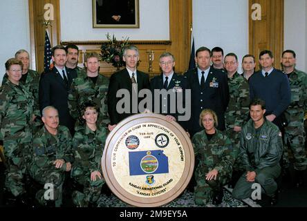 16 Mitglieder des 190. Air Tanken Flügels, Kansas Air National Guard, präsentieren Kansas Gouverneur Bill Graves am 23. März 2000 eine Plakette für seine Unterstützung der 1999 Missionen der Einheit. Die in Topeka, Kansas, stationierte KC-135-Einheit wurde zweimal zur Unterstützung der Operation Northern Watch in der Türkei auf dem Luftwaffenstützpunkt Incirlik eingesetzt und diente auch in den ersten Wochen der Operation Allied Force. Gouverneur Graves (Zentrum) nahm die Tafel von 190. ARW Commander, Colonel Rufus L. Forrest, Jr. (links von Gov Graves) während einer Zeremonie im Kansas Statehouse an. Die Metall- und Holztafel wurde von türkischem A entworfen und gebaut Stockfoto