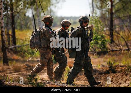 EIN US-AMERIKANISCHER Soldat im 1. Bataillon, 8. Infanterie-Regiment, 3. Kampfteam der Panzerbrigade, 4. Infanterie-Division, Und deutsche Soldaten, die dem 212. Panzergrenadier-Bataillon, der 21. Panzerbrigade, der 1. Panzerdivision zugeteilt wurden, ziehen während einer Feuerübung als Teil von Defender Europe in den Oberlausitz-Trainingsbereich, Deutschland, 19. Mai 2022. Defender Europe 22 ist eine Serie von US-amerikanischen Multinationale Ausbildungsübungen der Armee in Europa und Afrika in Osteuropa. Die Übung zeigt, dass die USA Die Fähigkeit der Armee Europa und Afrika, groß angelegte Bodenkampfoperationen überall durchzuführen Stockfoto