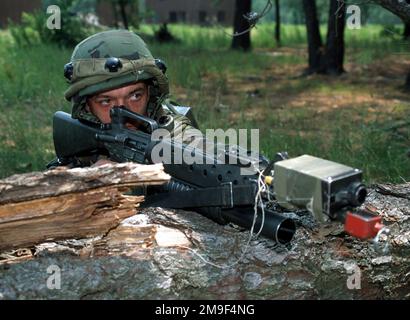 Gerade auf mittlerer Nahaufnahme des USAF-AIRMAN First Class Jodey Powell, 94. Sicherheitsstaffel, Dobbins Air Force Base, Georgia, während er sich hinter einem umgestürzten Baum versteckt und sein M16-Gewehr mit einem M203-mm-Granatwerfer abzielt. Das Gewehr und A1C Powells Kevlar-Helm sind mit M.I.L.E.S. ausgestattet (Multiple Integrated Laser Engagement System) Zahnrad. A1c Powell ist Teil einer Gruppe von 220 Air Force-Mitgliedern, die an Phoenix Readiness in Fort Dix, New Jersey, teilnehmen. (Doppeltes Bild, siehe auch DF-SD-01-01616 oder suchen Sie nach 000626-F-0007M-004). Betreff Betrieb/Serie: PHOENIX READINE Stockfoto