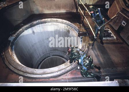 Das Wartungspersonal der US-Luftwaffe in einem Raketensilo der Friedenssicherungskräfte der Vandenberg AFB, CA, überprüft die Raketenrohre auf Schäden, die während des Starts aufgetreten sein könnten. Aus DEM AIRMAN Magazine, Juli 2000 Artikel "Peacekeeper 2000". Das Wartungspersonal der US-Luftwaffe in einem Raketensilo der Friedenssicherungskräfte der Vandenberg AFB, CA, überprüft die Raketenrohre auf Schäden, die während des Starts aufgetreten sein könnten. Aus dem Airman Magazine, Juli 2000 Artikel "Peacekeeper 2000". Stockfoto