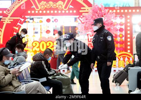 SHENYANG, CHINA - 18. JANUAR 2023 - Polizeibeamte bedienen Passagiere in der Wartehalle eines Bahnhofs in Shenyang, Provinz Liaoning, China, Stockfoto