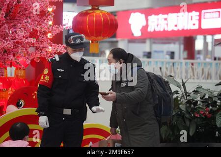 SHENYANG, CHINA - 18. JANUAR 2023 - Polizeibeamte bedienen Passagiere in der Wartehalle eines Bahnhofs in Shenyang, Provinz Liaoning, China, Stockfoto