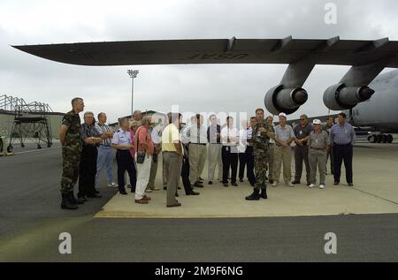 Gerade auf mittlerer Stufe stehen Bürgermeister aus Abilene, Texas, unter dem linken Flügel eines US Air Force C-5 Galaxy Frachtflugzeugs auf der Fluglinie des Dover Air Force Base, Delaware. Die Texaner waren in Dover, um den Führern dort am 27. Juli 2000 die Trophäe des Abilene Community Award zu überreichen. Basis: Luftwaffenstützpunkt Dover Bundesstaat: Delaware (DE) Land: Vereinigte Staaten von Amerika (USA) Stockfoto