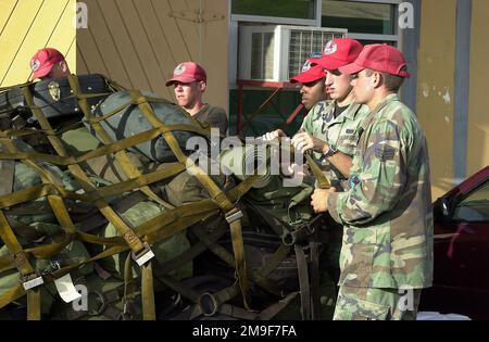 MITGLIEDER DER US Air Force, 820. ROTES PFERD, Nellis Air Force Base, Nevada, ziehen Sie vor dem Abflug von Grenada am 7. August 2000 die Frachtnetze fest, die ihre Gepäckpalette bedecken. Das rote PFERD der Air Force aus dem Jahr 820. und das Ingenieurstützbataillon der Marine aus dem Jahr 8., Camp Lejeune, North Carolina (Marines nicht abgebildet), sind Teil einer größeren humanitären Übung, die vom USSOUTHCOM (United States Southern Command) gesponsert wird und mit dem Bau eines Gemeindezentrums, Kasernen und einer Schule beauftragt ist. Diese Übung, New Horizons 2000, findet an verschiedenen Orten in der Karibik und Südamerika statt. Betreffvorgang Stockfoto