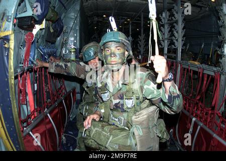 Gerade aus mittlerer Nahaufnahme, während US Army Sergeant Jeremy Cowham, Jumpmaster und seine anderen Fallschirmjäger der 1. Des 508. Infanterie Airborne Battalion Combat Team (ABCT), 173. Airborne Brigade aus Vicenza, Italien, an Bord einer US Air Force C-130 Hercules von der 37. Luftwaffenstaffel Ramstein Air Base warten, Deutschland, während sie sich am 09. August 2000 für Lion Drop 12 in der Bunker Drop Zone in Grafenwohr, Deutschland, vorbereiten. Betreff Betrieb/Serie: LION DROP 12 Land: Deutschland / Deutschland (DEU) Stockfoto