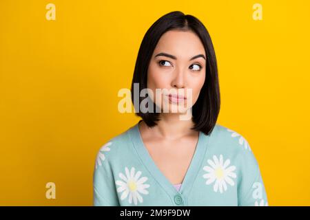 Großaufnahme Foto von lustigen Augenbrauen koreanisches Mädchen trägt stilvollen blaugrünen Pullover Look leer Neues Luxusrestaurant isoliert auf gelbem Hintergrund Stockfoto