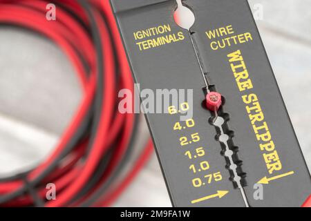 Nahaufnahme des in China hergestellten Abisolierers und Drahtschneiders ohne Markenkennzeichnung für 26-10AWG-Draht (siehe Hinweise) mit Spiralkabeln. Stockfoto