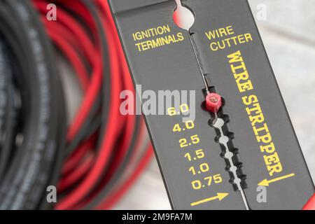 Nahaufnahme des in China hergestellten Abisolierers und Drahtschneiders ohne Markenkennzeichnung für 26-10AWG-Draht (siehe Hinweise) mit Spiralkabeln. Stockfoto