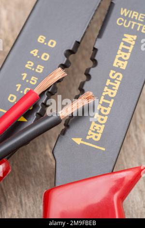 Nahaufnahme des in China hergestellten Abisolierers und Drahtschneiders ohne Markenkennzeichnung für 26-10AWG-Draht (siehe Hinweise) mit abisolierten Steckverbinderdrähten. Stockfoto