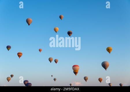 Kappadokien, Türkei-September 20 2022: Viele farbenfrohe Ballons auf dem Hintergrund eines hellblauen Himmels Stockfoto