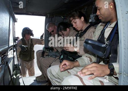 SERGEANT Michael Schantz, Flight Medic, 571. Medical Company, Fort Carson, Colorado, Stellt sicher, dass Passagiere vor dem Start vom Luftwaffenstützpunkt Prince Sultan, Saudi-Arabien, während einer medizinischen Übung ordnungsgemäß in einem UH-60 Black Hawk Helikopter festgeschnallt sind. SSGT Schantz ist Teil der Koalitionstruppe hier, um die Operation SOUTHERN WATCH zu unterstützen, eine militärische Anstrengung zur Durchsetzung der Flug- und Fahrverbotszone im Südirak. Betreff Operation/Serie: SÜDLICHE WACHSTATION: Prince Sultan Luftwaffenstützpunkt Land: Saudi-Arabien (Sau) Stockfoto