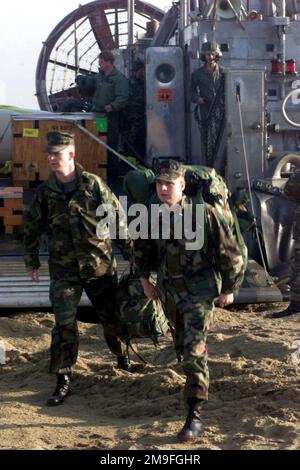 US Marine First Lieutenant Jonathon Kehr (rechts), Landing Support Detachment, 31. Marine Expeditionary Unit, Okinawa, Japan, verlässt Landing Craft Air Cushoned (LCAC) LC 81, von Assault Craft Unit-5 (ACU-5) Detachment West Pacific, Sasebo, Japan, An einem Gogu Beach für die D-Day Mobile Fuel Distribution System (DMFDS) Konzeptdemonstration zur Unterstützung DES FOHLEN EAGLE 2000. Das DMFDS ist ein von dem Force Warfighting Lab (FWL) gefördertes und vom Office of Naval Research (ONR) finanziertes Projekt, das neue Techniken beim ersten Treibstofftransport vom Meer auf das Land demonstriert. FOHLEN ADLER ist das größte J Stockfoto