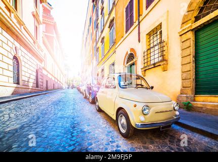 Kleines Oldtimer in einer wunderschönen Straße in Rom, Italien. Klassisches Retro-Auto in farbenfroher Straße. Stockfoto