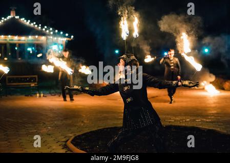 SEMIGORYE, OBLAST IVANOVO, RUSSLAND - 28. APRIL 2017: Feuershow mit brennenden glitzernden Fackeln von professionellen Künstlern in Kostümen Stockfoto