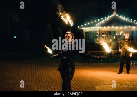 SEMIGORYE, OBLAST IVANOVO, RUSSLAND - 28. APRIL 2017: Feuershow mit brennenden glitzernden Fackeln von professionellen Künstlern in Kostümen Stockfoto