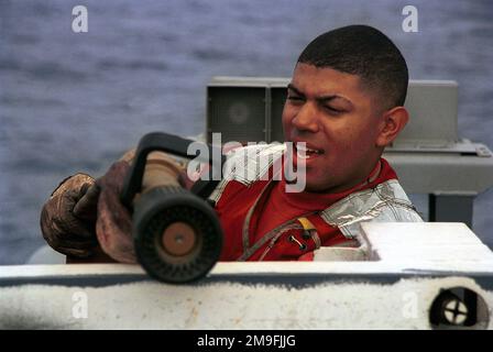 Aviation Boatswain's Mate Handler Third Class Demetrius Williams hebt während der an Bord der USS Harry S. Truman (CVN 75) durchgeführten Feuerlöschübung einen Feuerwehrschlauch über die Deckkante des Cockpits. TRUMAN ist auf einem geplanten sechsmonatigen Einsatz im Mittelmeer und im Arabischen Golf. Basis: USS Harry S. Truman (CVN 75) Land: Atlantik (AOC) Stockfoto