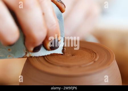 Zugeschnittenes Nahbild. Frauenhände formten Ton, machten Tontöpferwaren in der Kunsthandwerkstatt. Handwerklich hergestelltes Steingut-Konzept. Makro sh Stockfoto