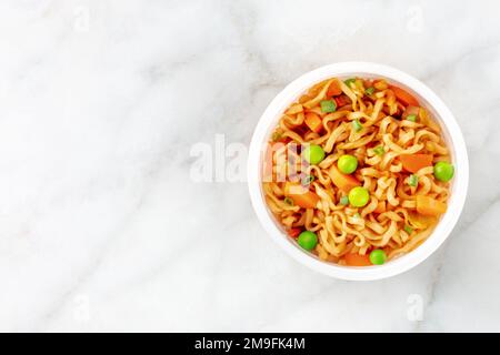 Ramen-Tasse, Instant-Soba-Nudeln in einem Plastikbecher mit Gemüse, von oben mit Kopierraum geschossen Stockfoto