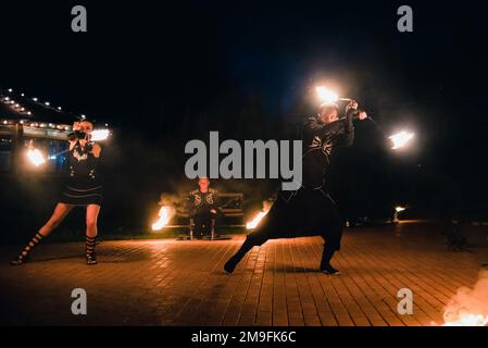 SEMIGORYE, OBLAST IVANOVO, RUSSLAND - 16. JULI 2016: Gefährliche Feuershow vom Team professioneller Künstler mit brennenden Fackeln und Funken Stockfoto