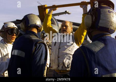 FOX Sports Prominente Terry Bradshaw demonstriert den Mitgliedern der Cockpit-Crew während seines Besuchs an Bord der USS Harry S. Truman (CVN 75) eine alternative Verwendung von Radkeilen. Der Gastgeber von Fox Sports nimmt an Bord VON TRUMAN die beliebte NFL Pre-Game Show auf, die im Dezember 2000 im FOX Network ausgestrahlt wurde. TRUMAN ist auf einem geplanten sechsmonatigen Einsatz im Mittelmeer und im Arabischen Golf. Basis: USS Harry S. Truman (CVN 75) Land: Atlantik (AOC) Stockfoto