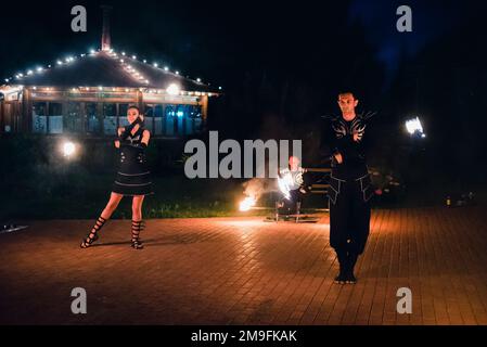 SEMIGORYE, OBLAST IVANOVO, RUSSLAND - 16. JULI 2016: Gefährliche Feuershow vom Team professioneller Künstler mit brennenden Fackeln und Funken Stockfoto