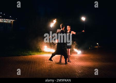 SEMIGORYE, OBLAST IVANOVO, RUSSLAND - 16. JULI 2016: Gefährliche Feuershow vom Team professioneller Künstler mit brennenden Fackeln und Funken Stockfoto