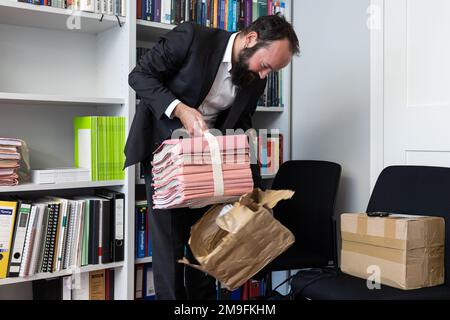 Wiesbaden, Deutschland. 27. Okt. 2022. Martin Rettenberger, Direktor des Kriminalzentrums (KrimZ), entpackt die Prozessakten in seinem Arbeitszimmer. Die KrimZ ist eine Forschungs- und Dokumentationseinrichtung der Bundes- und Landesregierungen auf dem Gebiet der Strafjustiz. Kredit: Hannes P. Albert/dpa/Alamy Live News Stockfoto