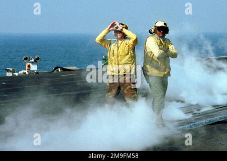 US Navy Aviation Boatswain's Mate AIRMAN (Handler) Ethan Lane leitet ein Flugzeug auf eines der Katapulte an Bord der USS HARRY S. TRUMAN (CVN 75), während US Navy Aviation Boatswain's Mate (Handler) Milton Jimison der zweiten Klasse seine Handlungen überwacht. Truman ist auf Station im Persischen Golf, um die Operation SÜDWACHE zu unterstützen. Betreff Betrieb/Serie: SÜDLICHE WACHSTATION: USS Harry S. Truman (CVN 75) Stockfoto
