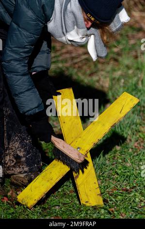 Erkelenz, Deutschland. 18. Januar 2023. Ein Aktivist reinigt ein Gelbes Kreuz in Keyenberg vor einer Pressekonferenz über die Proteste in Lützerath. Kredit: Henning Kaiser/dpa/Alamy Live News Stockfoto