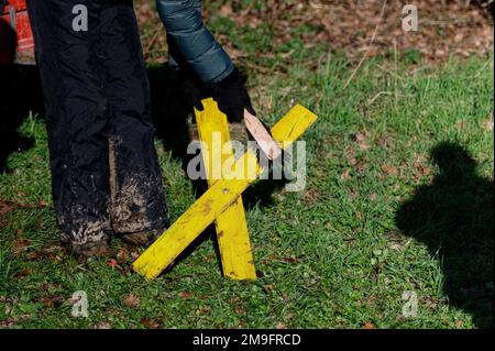 Erkelenz, Deutschland. 18. Januar 2023. Ein Aktivist reinigt ein Gelbes Kreuz in Keyenberg vor einer Pressekonferenz über die Proteste in Lützerath. Kredit: Henning Kaiser/dpa/Alamy Live News Stockfoto