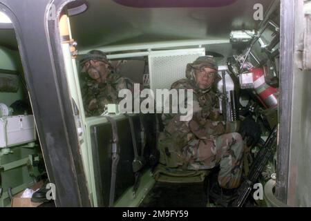US Marine Corps (USMC) Hospital Corpsman (HM) Dan Ocampo (links) und USMC Corporal (CPL), Michael Probst, beide der C/Company zugewiesen, 3. Light Armored Reconnaissance (LAR) Battalion, 1. Marine Division, sitzen in einem Light Armored Vehicle (LAV-25) während des ÜBUNGSKERNELS BLITZ 2001. Betreff Betrieb/Serie: KERNEL BLITZ 2001 Base: Marine Corps Base Camp Pendleton Bundesstaat: Kalifornien (CA) Land: Vereinigte Staaten von Amerika (USA) Stockfoto