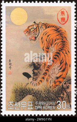 Nordkoreanische Briefmarke aus dem Jahr 2010 mit einem traditionellen Gemälde eines koreanischen Tigers unter Vollmond für das Jahr des Tigers. Stockfoto