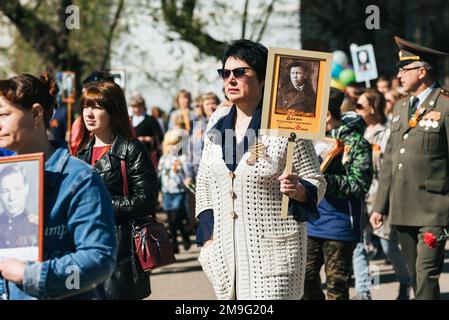 VICHUGA, RUSSLAND - 9. MAI 2015: Unsterbliches Regiment - Menschen mit Porträts ihrer Verwandten, Teilnehmer des Zweiten Weltkriegs, am Siegesfeiertag Stockfoto