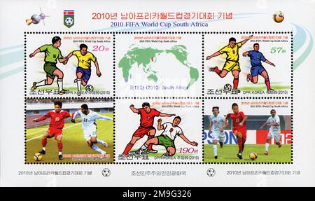 Nordkoreanischer Briefmarkenbogen zum Gedenken an die FIFA Fussball-Weltmeisterschaft 2010 in Südafrika mit Fußballspielern und einer Weltkarte. Stockfoto