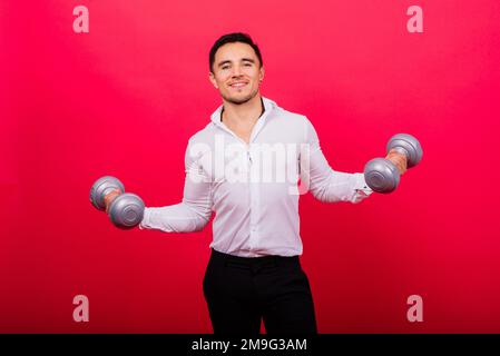 Geschäftsmann mit Fitness-Kurzhanteln trägt Hemd. Studioaufnahmen auf rotem Hintergrund Stockfoto