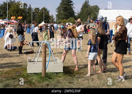 Am Ende des Road Festivals, Larmer Tree Gardens, an der Grenze von Nord-Dorset und Wiltshire, Großbritannien, warten die Menschen in der Schlange, um Trinkwasserflaschen zu füllen Stockfoto